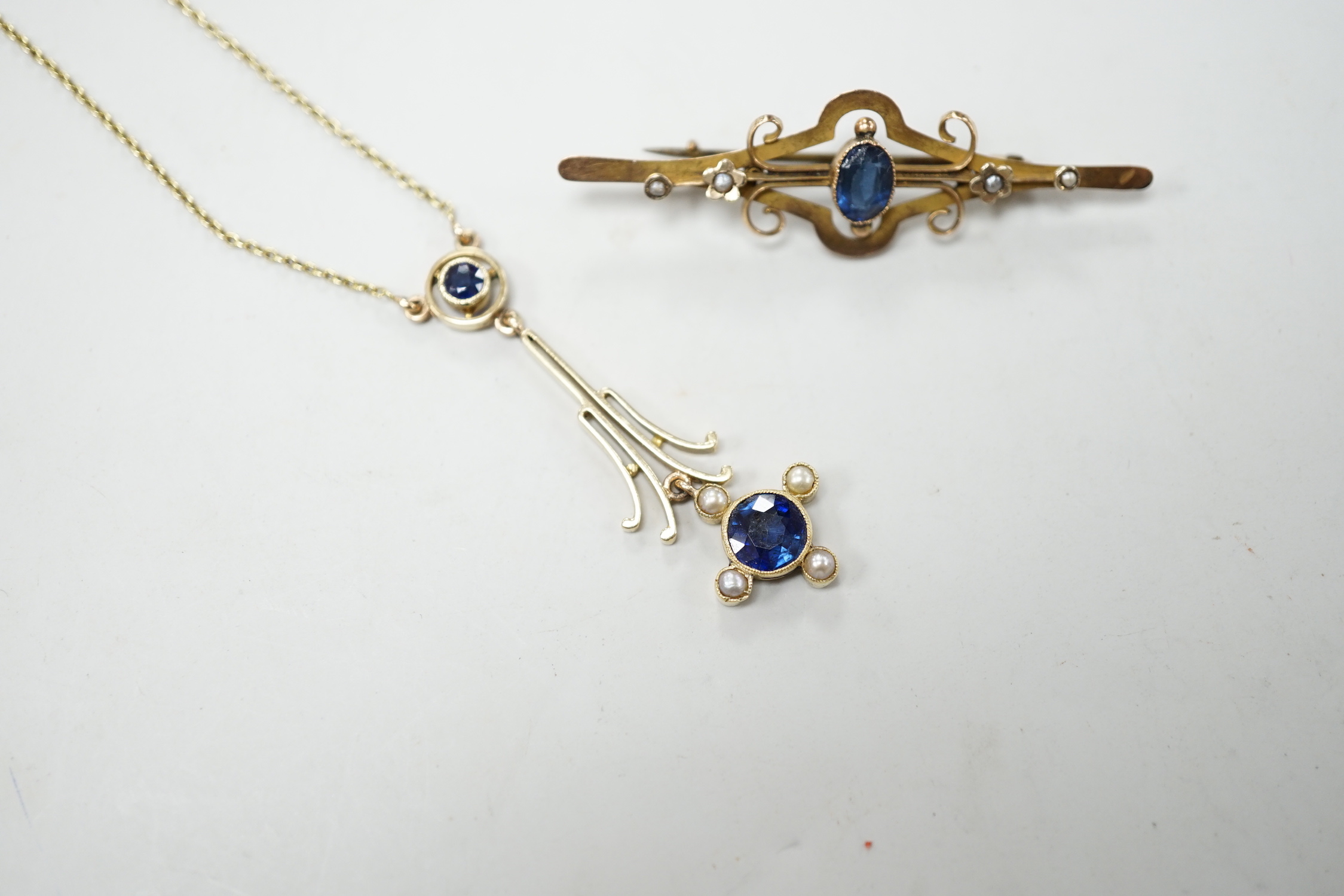 An Edwardian 15ct gold, sapphire and seed pearl set drop pendant necklace, overall 52cm, gross weight 4.5 grams and one other yellow metal and gem set bar brooch.